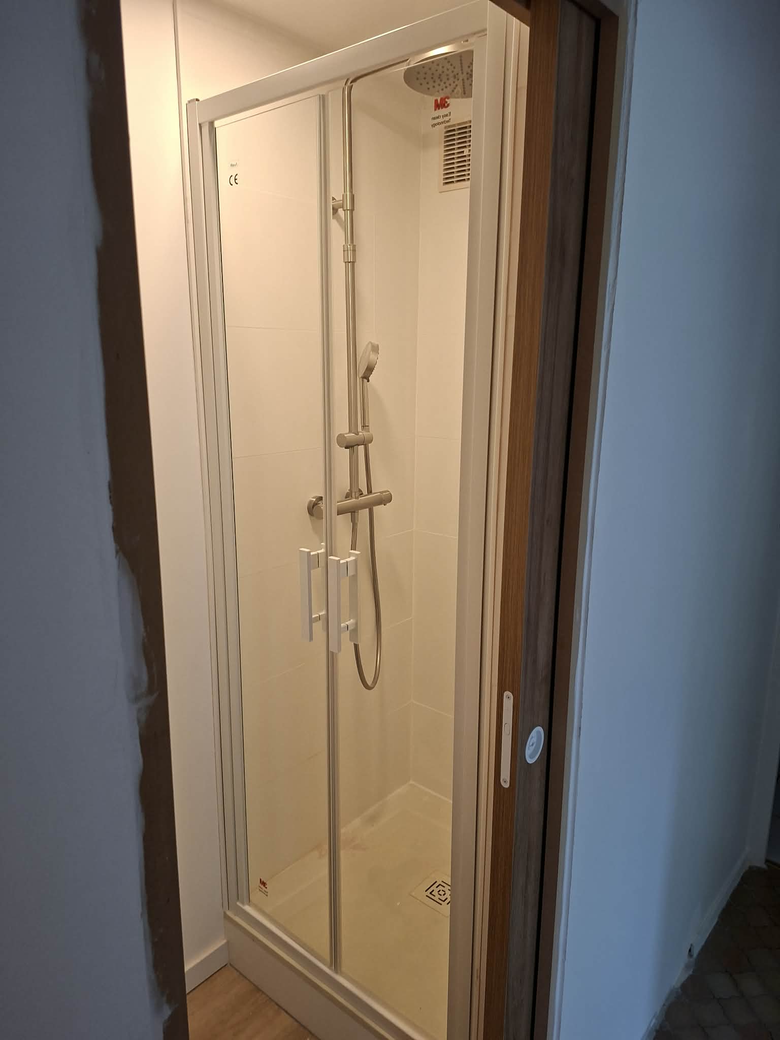Douche gain de place avec porte battante dans une salle de bain créée à Déville-lès-Rouen
