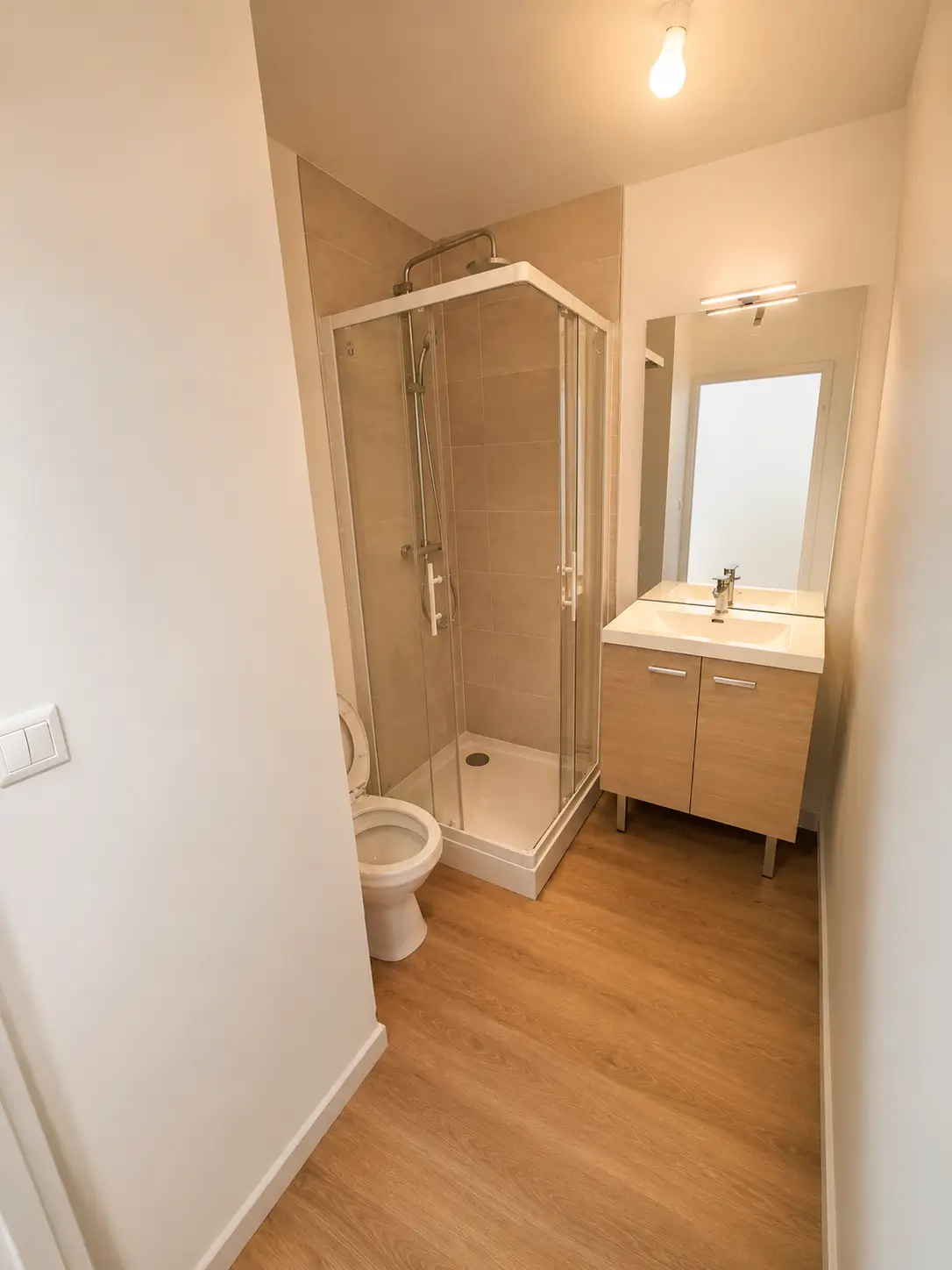 Salle de bain rénovée secteur Saint-Gervais à Rouen avec douche, meuble vasque, WC et sol en lames PVC