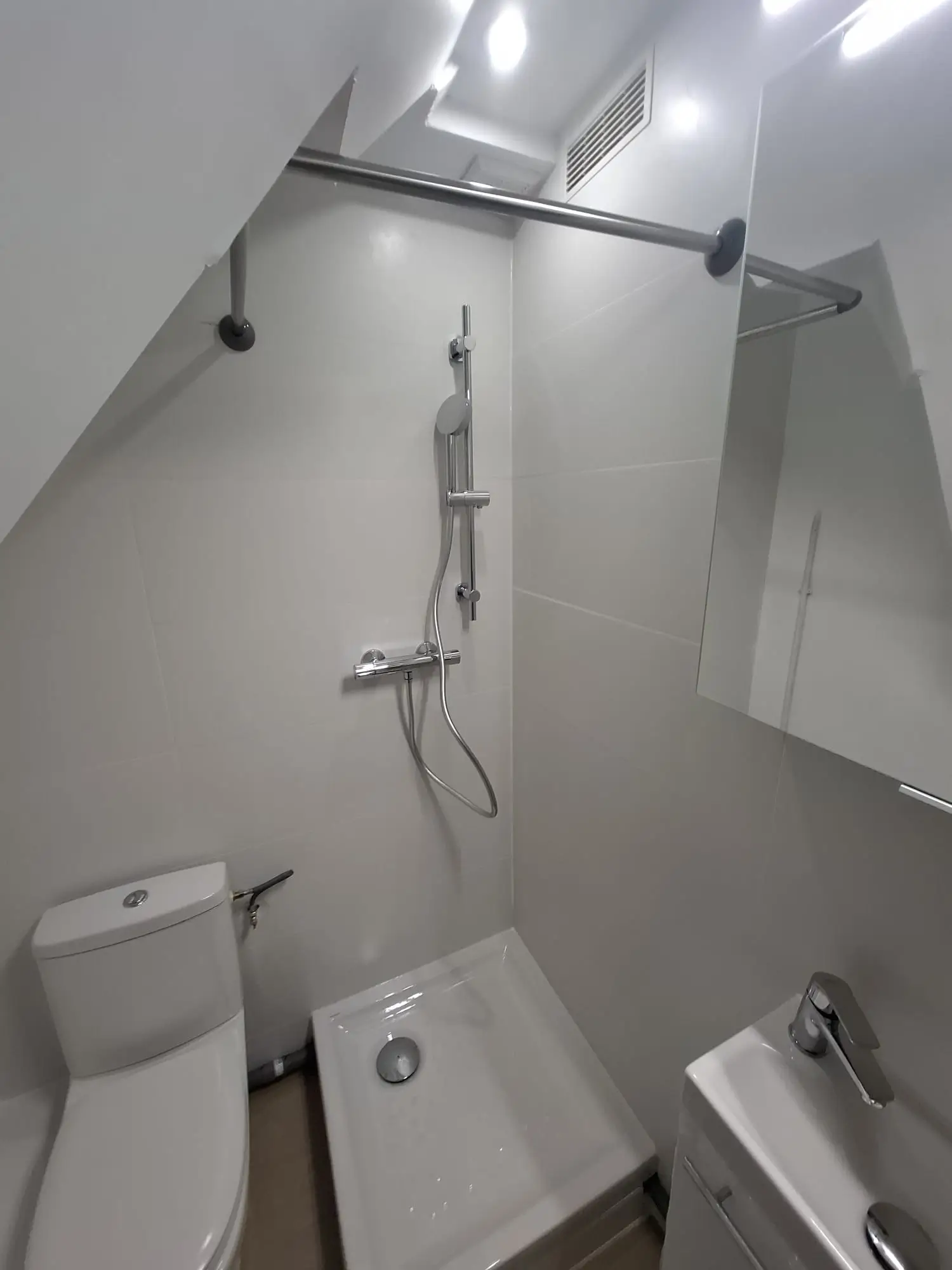 Meuble vasque suspendu moderne dans une salle de bain rénovée sous combles à Rouen Rougemare