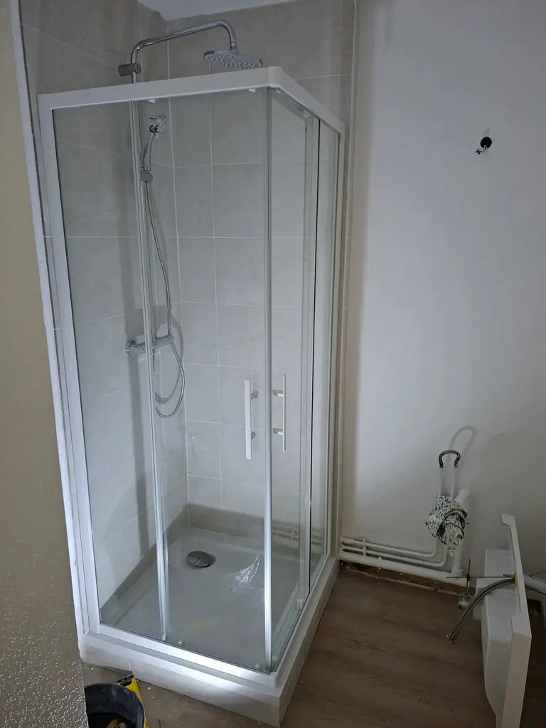 Douche rénovée avec parois vitrées et carrelage mural dans une salle de bain à Rouen Saint-Gervais