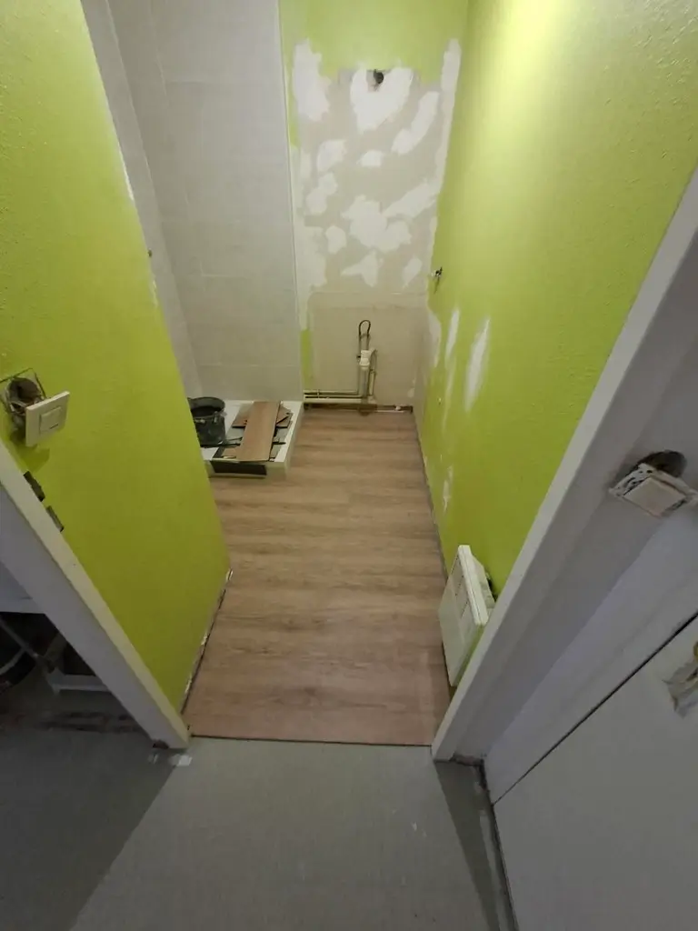 Pose de lames PVC au sol pendant la rénovation d'une salle de bain secteur Saint-Gervais à Rouen